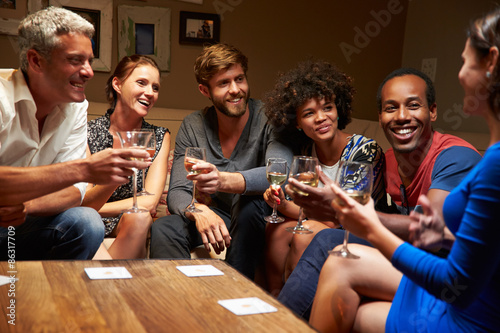 Wall Mural Group of friends sitting around a table at house party