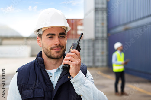 Photos Young Attractive docker using talkie walkie at work