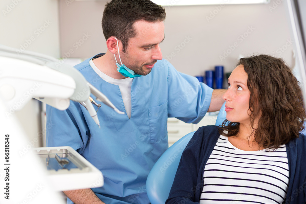 Young attractive dentist explaning his work to a patient Young attractive dentist explaning his work to a patient