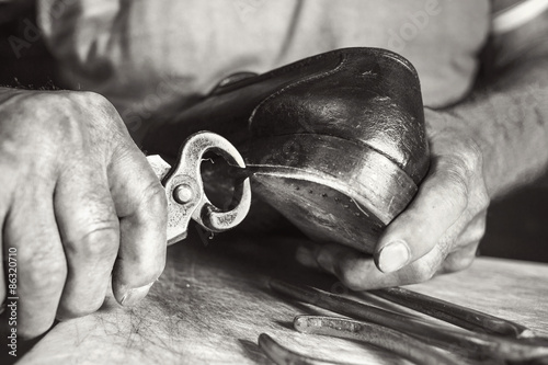 old artisian shoemaker repair black shoes photo