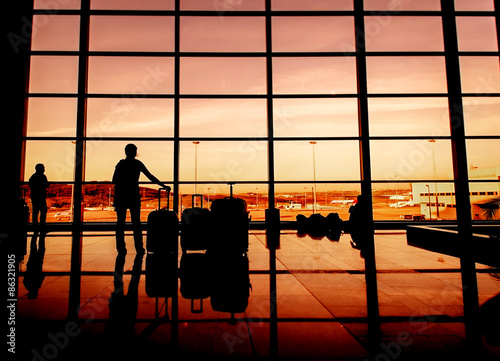 Silhouette of airline passengers in an airport lounge at the