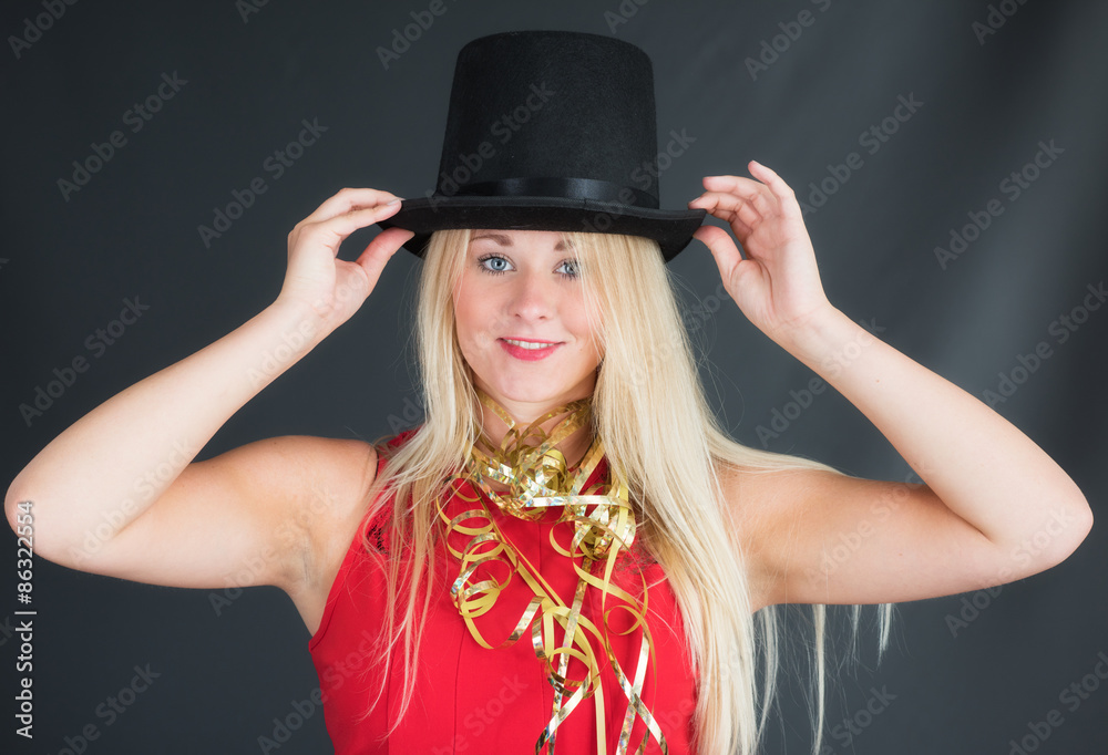 Blondine mit Zylinder und Luftschlangen im Portrait