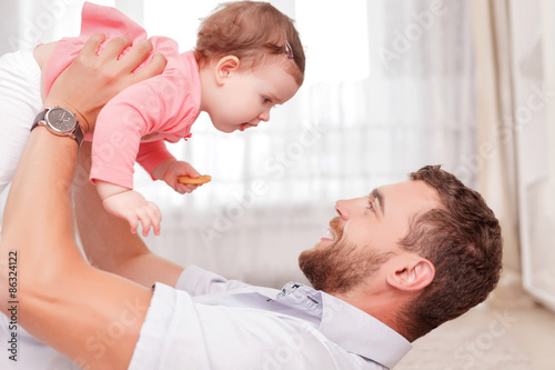 Vivacious father holding his kid in air 