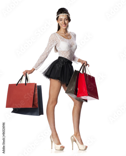 Portrait of a beautiful young brunette woman posing with shoppin