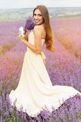 Pretty smiling girl is wearing dress at purple lavender field