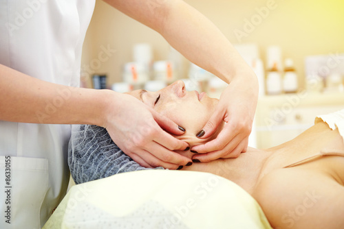 woman getting facial massage and relaxing
