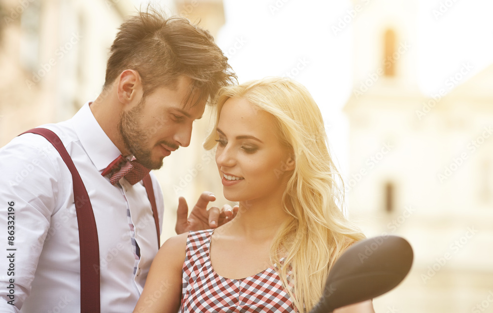 Naklejka premium Love couple on the street with retro scooter