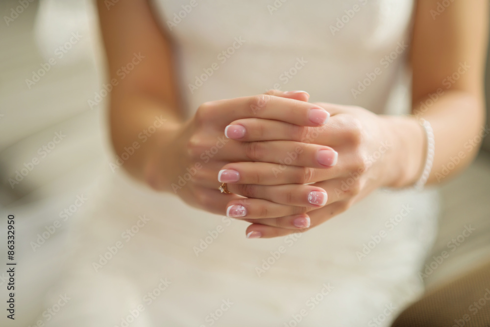 Beautiful female hands with manicure against a white dress Beautiful female hands with manicure against a white dress