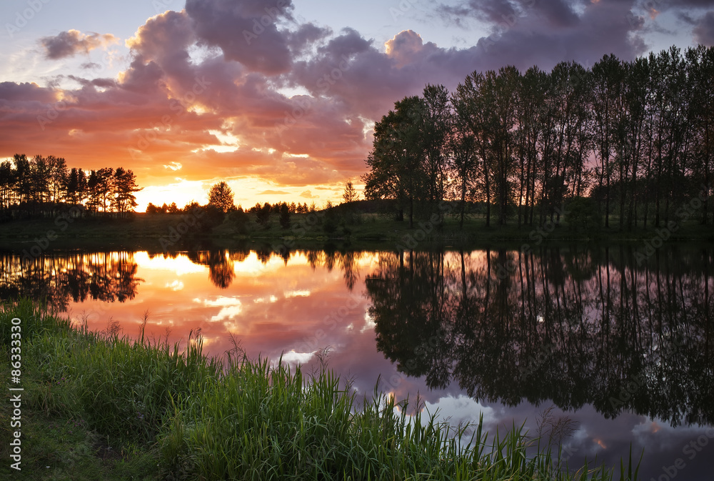 Obraz premium Beautiful landscape with fiery sunset over the lake in the villa
