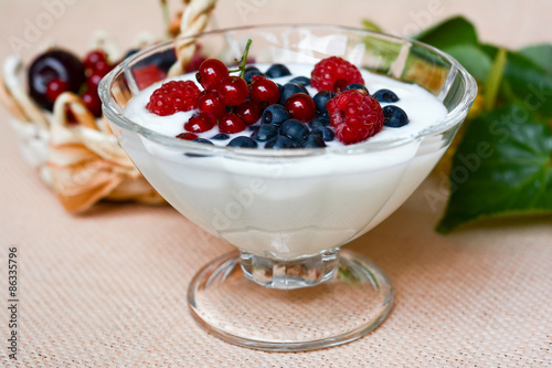 Yogurt with berries in glass bowl