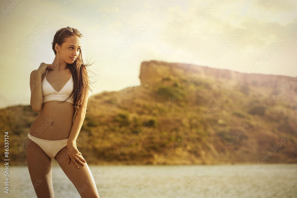Beautiful woman wearing a white swimsuit at the beach Beautiful woman wearing a white swimsuit at the beach