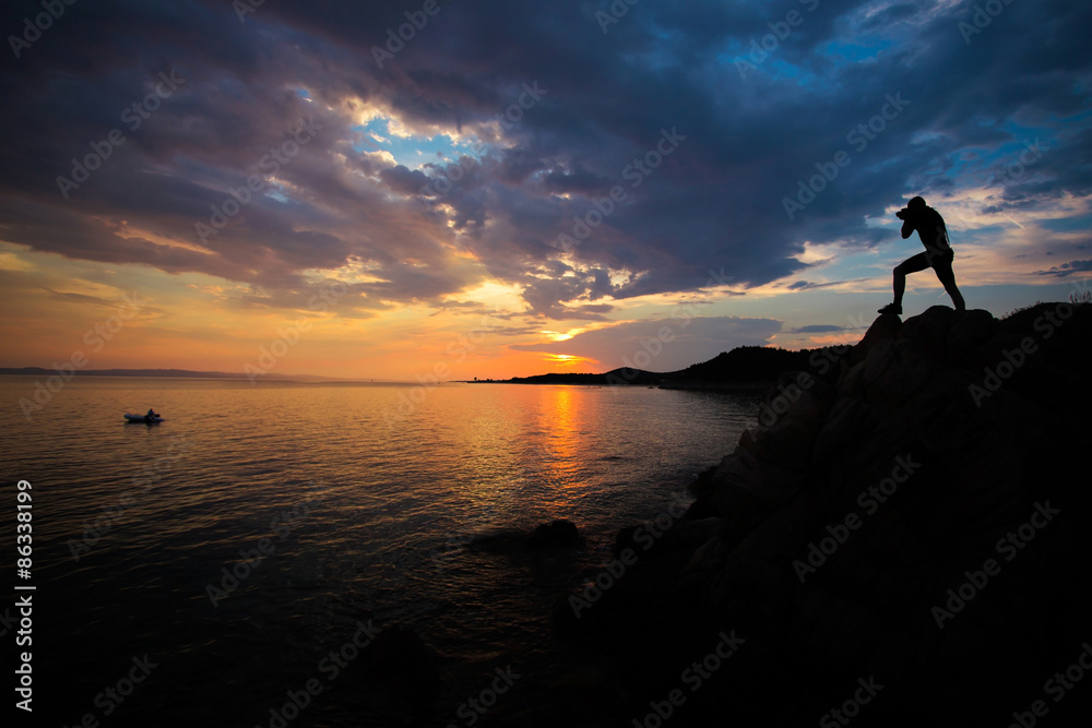 Man photographing landscape at sunset