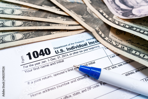 1040 individual tax return form and american dollar bills money closeup