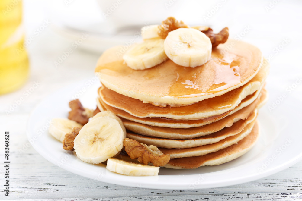 Tasty pancakes with banana and walnut on white wooden background Tasty pancakes with banana and walnut on white wooden background