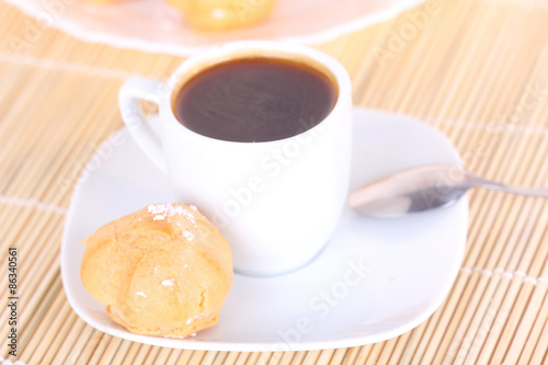 Cup of coffee and cake on wooden mat