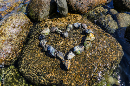Heart of colorful stones seawater photo