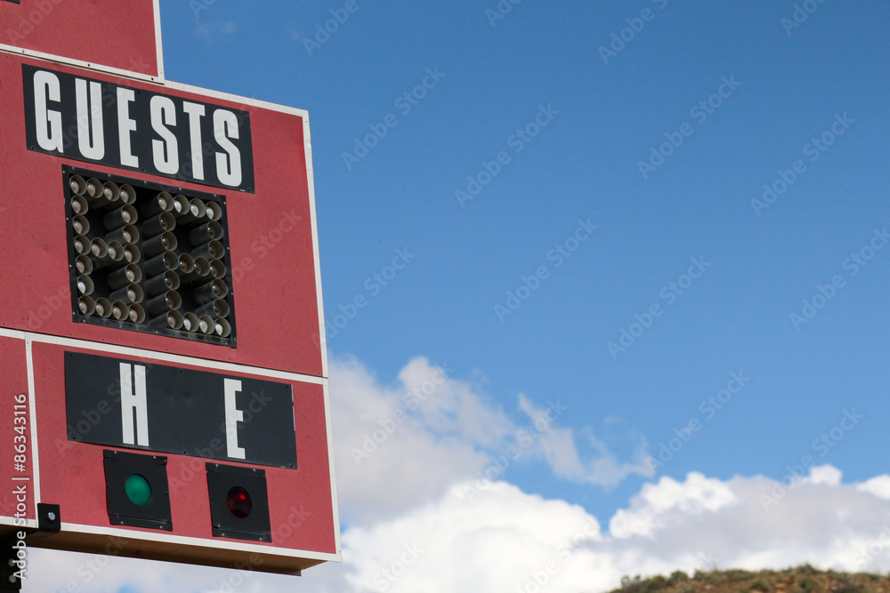 Obraz premium Lights on a red scoreboard to indicate the guest score at a softball field in New Mexico