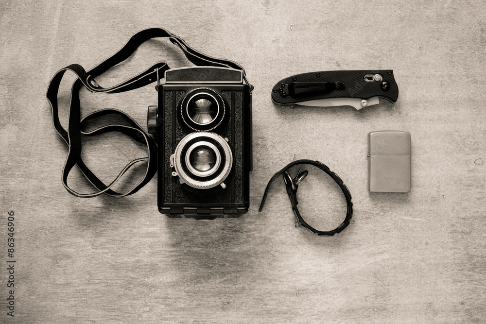 Vintage camera and old razor blade on wooden background