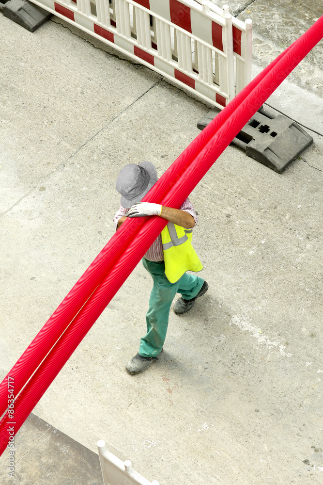 construction worker  carrying  pvc pipe