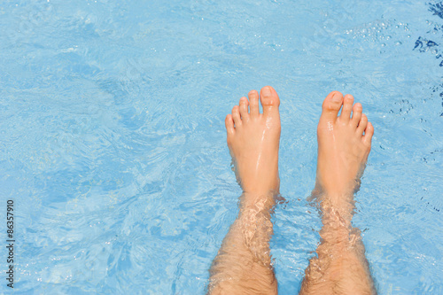 Male feet float on the water