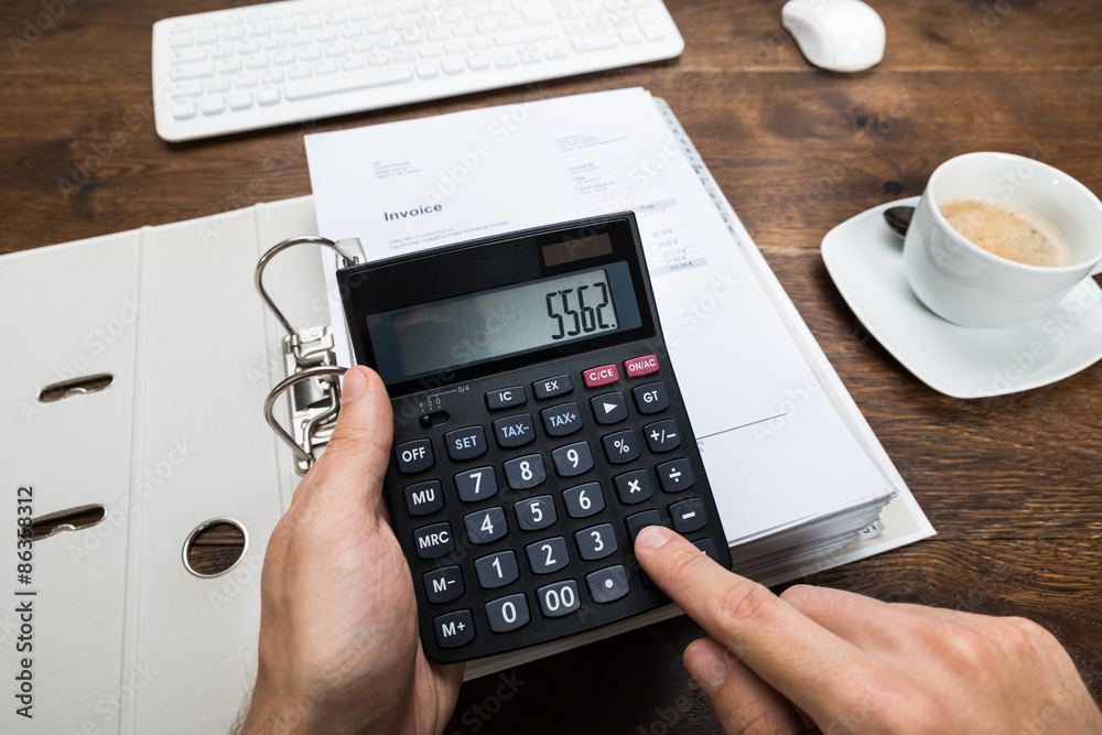 Person Hand Calculating Tax On Calculator Person Hand Calculating Tax On Calculator