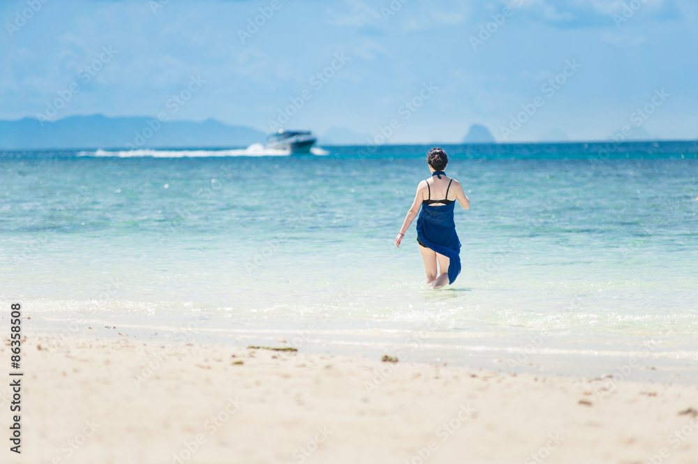 Girl walking in the sea at white sand beach Girl walking in the sea at white sand beach