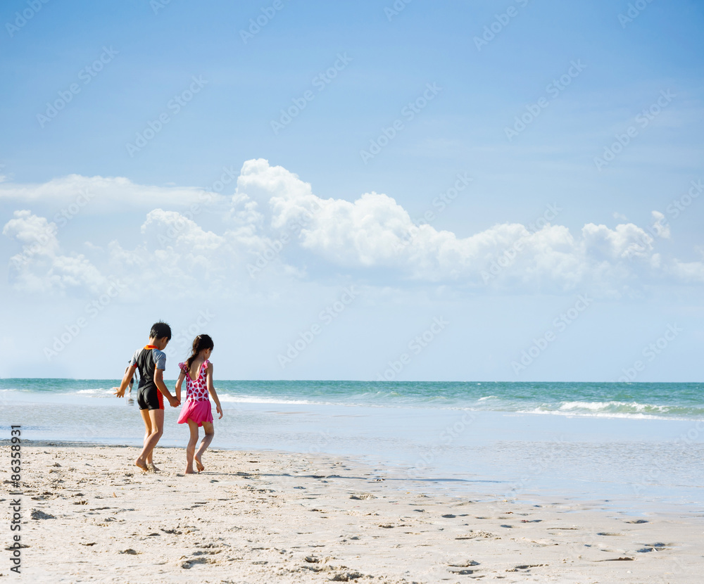 Brother sister holding hand walk on the beach Brother sister holding hand walk on the beach