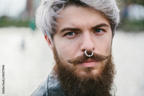 Bearded hipster with nose ring in leather jacket