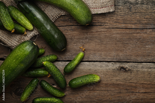 Zucchini and cucumbers on wooden background. Top view.