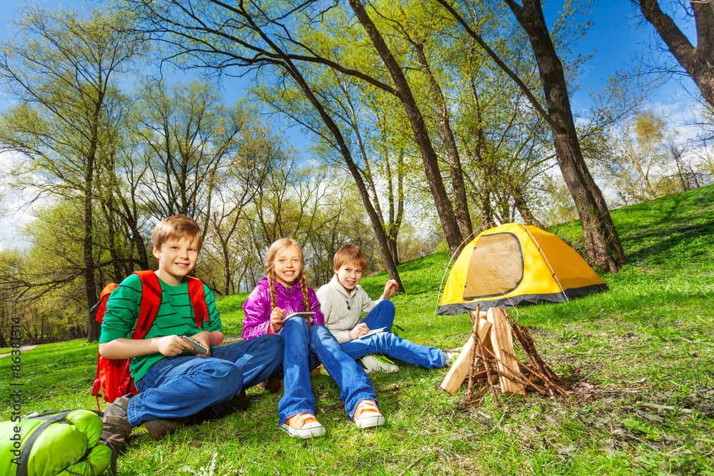 Obraz premium Happy children rest together near wooden bonfire