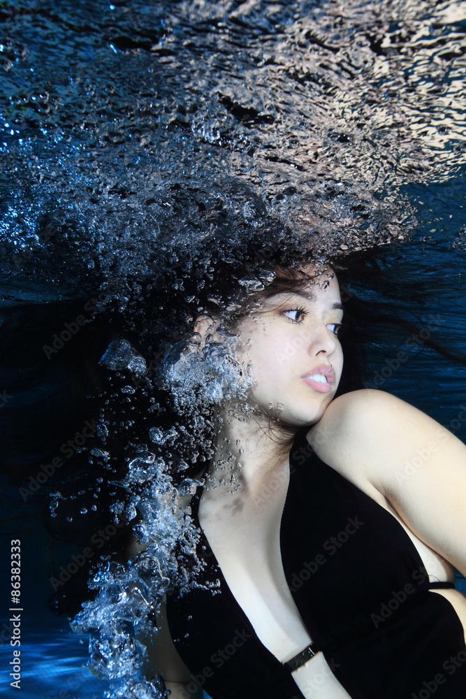 Fototapeta premium Young woman underwater with air bubbles 