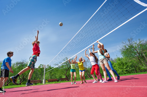 Teenagers play volleyball game on playing ground © Sergey Novikov