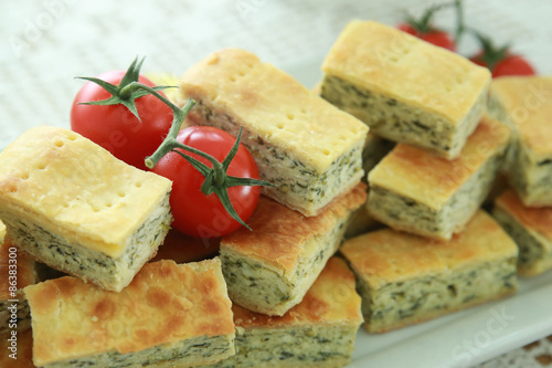 Homemade Ricotta cheese and spinach pie slice with tomato