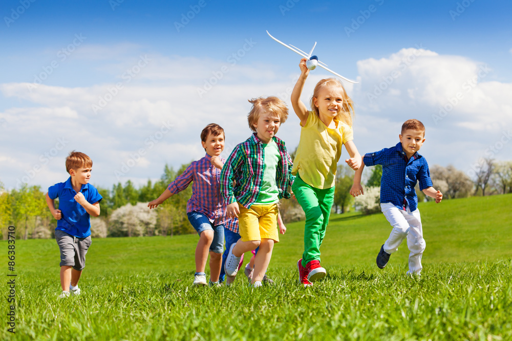 Group of happy running kids with white airplane Group of happy running kids with white airplane