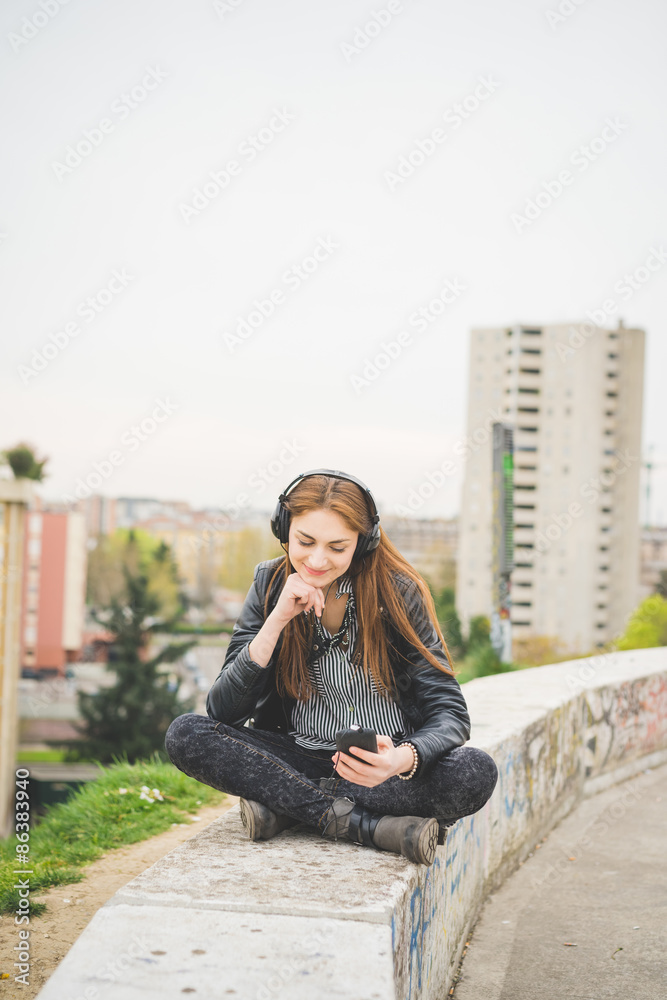 Fototapeta premium Young handosme brunette girl listening music