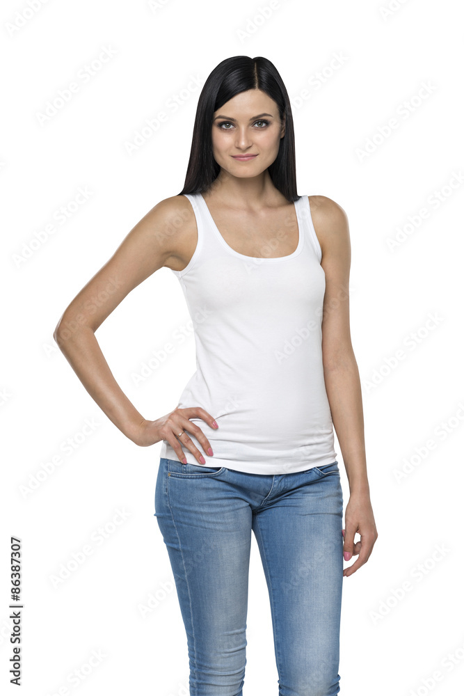 Close up of a brunette lady in a tank top and denims. Isolated.
