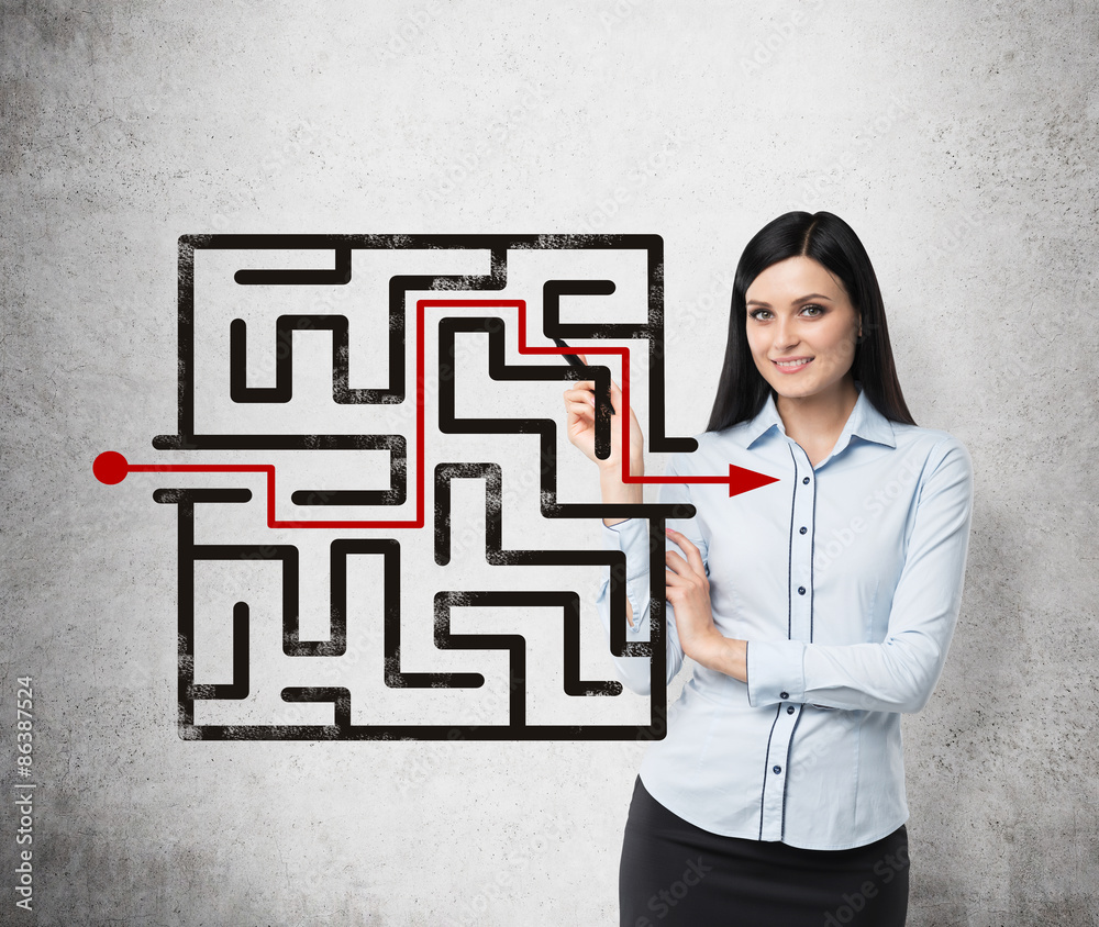 Brunette girl is looking for the solution of the maze. Concrete background. Brunette girl is looking for the solution of the maze. Concrete background.