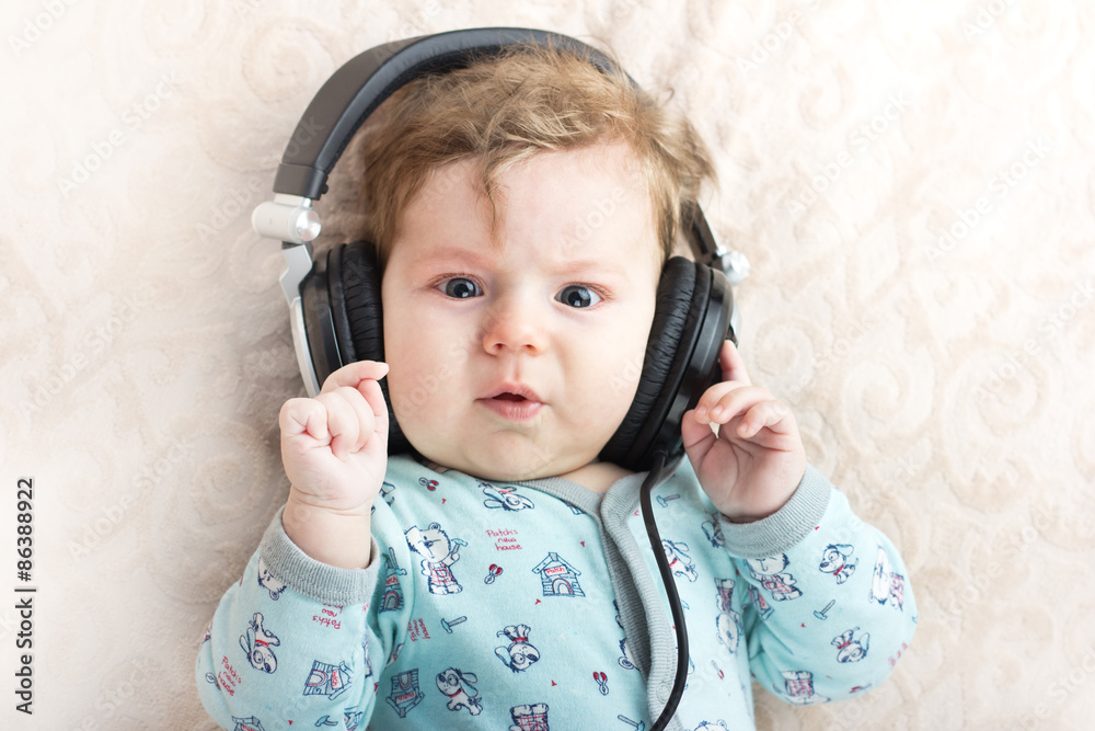 Funny baby in a big headphones. Portrait of a little boy. Cute child. Funny baby in a big headphones. Portrait of a little boy. Cute child.