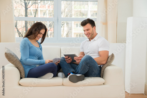 Smiling Couple Using Digital Tablet