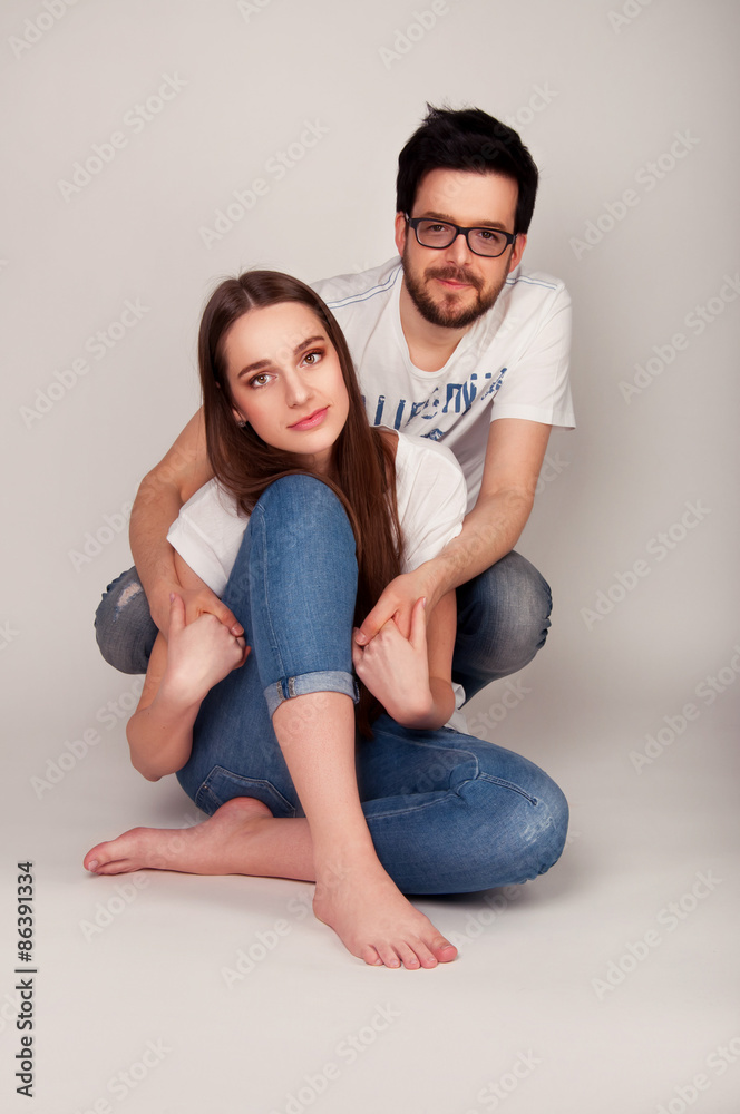 Young couple sitting close on the floor and holding hands