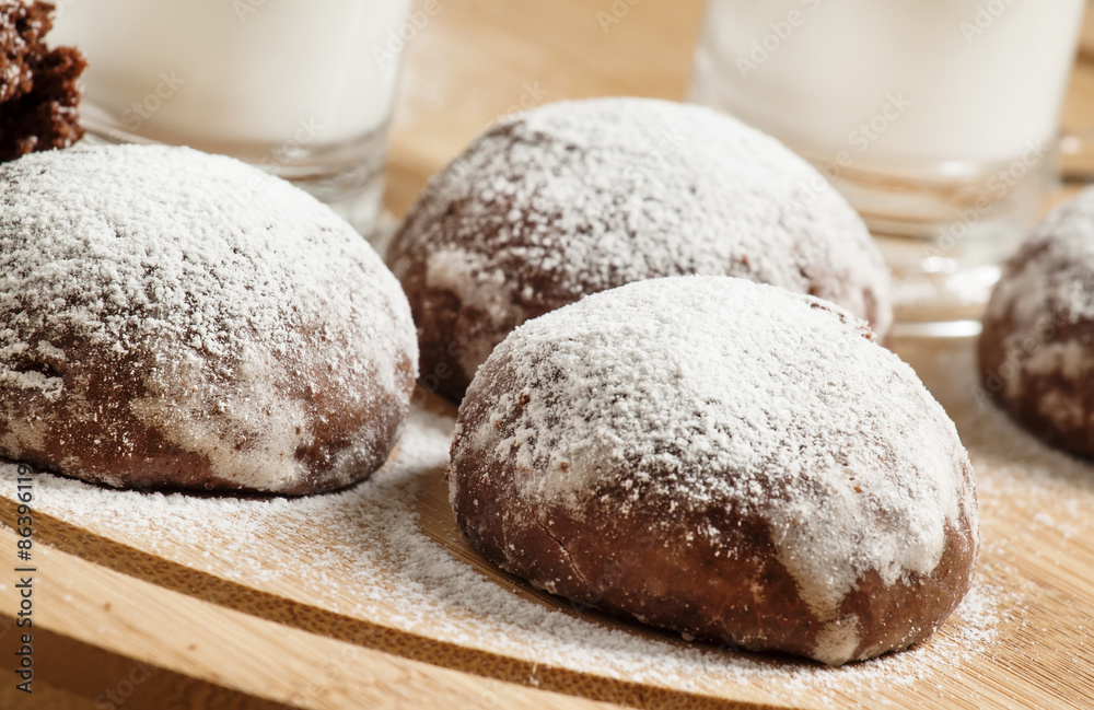 Homemade chocolate cookies sprinkled with powdered sugar and mil Homemade chocolate cookies sprinkled with powdered sugar and mil
