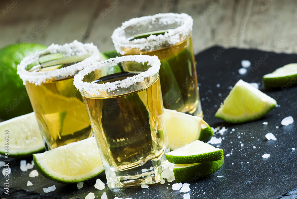 Gold Mexican tequila with lime and salt, selective focus Gold Mexican tequila with lime and salt, selective focus
