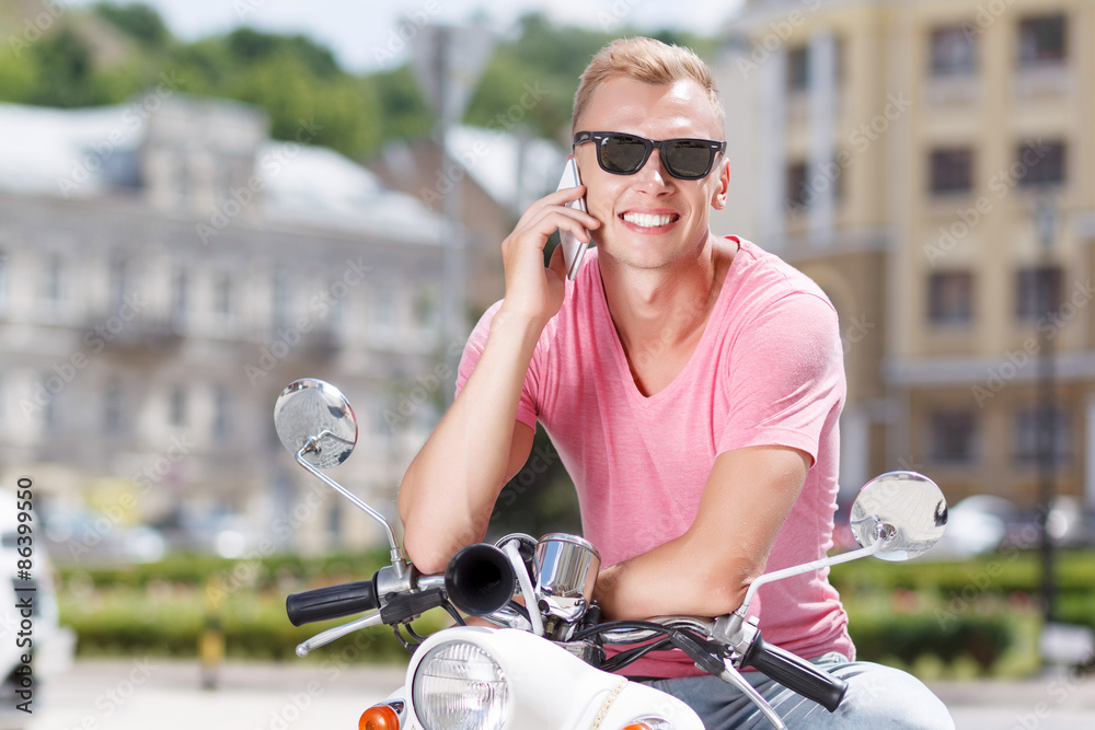 Fototapeta premium Handsome man doing selfie on scooter 