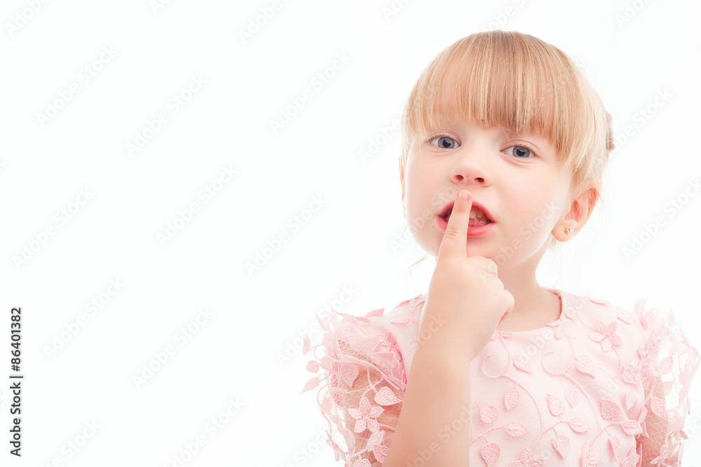 Nice little girl holding finger in front of mouth Nice little girl holding finger in front of mouth