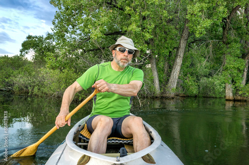 senior male paddler in canoe