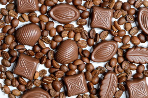 Assorted chocolate candy on the background of coffee beans isola