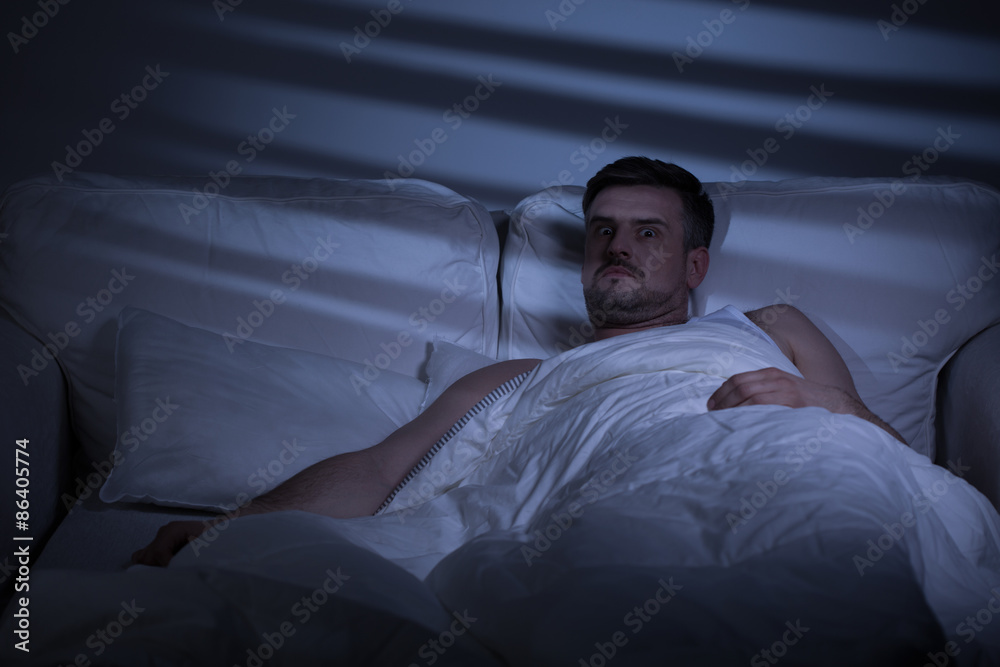 Terrified man in bed
