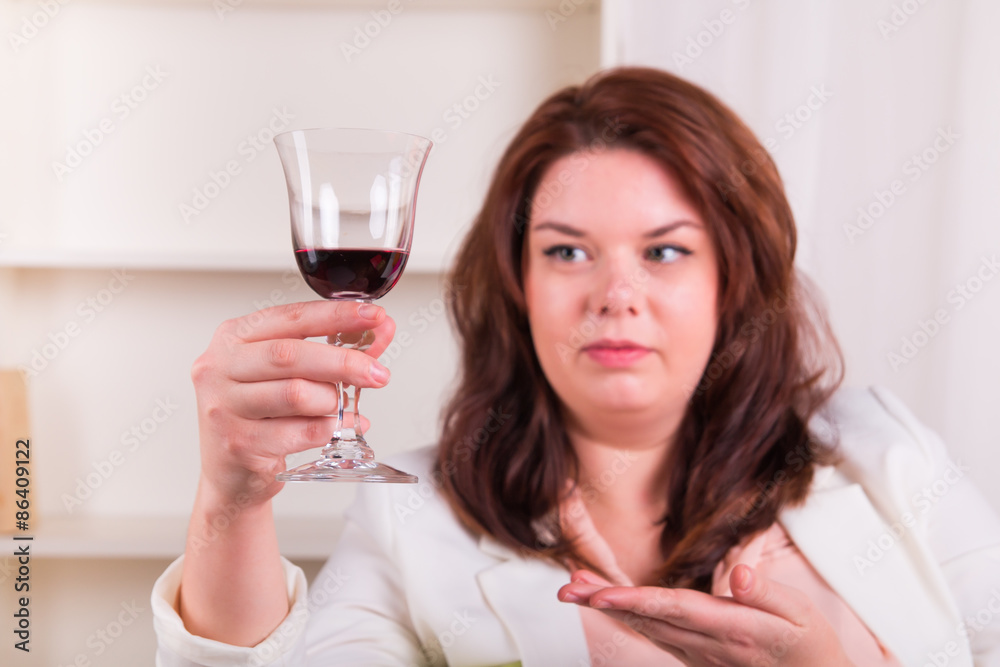 Plump and cheerful woman holding a glass of wine Plump and cheerful woman holding a glass of wine