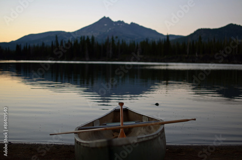 Canoe docked at Sparks lake with Broken Top Mountain in the background