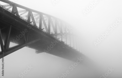 Sydney Harbour Bridge under the mist in black and white.
